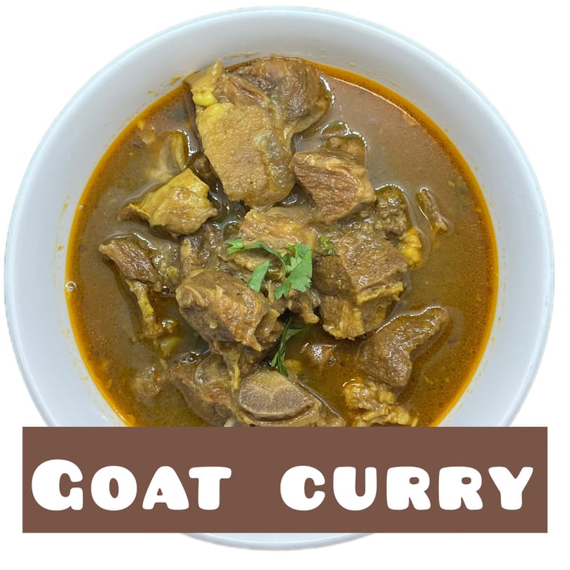 A white bowl filled with Indian goat curry, garnished with fresh cilantro.